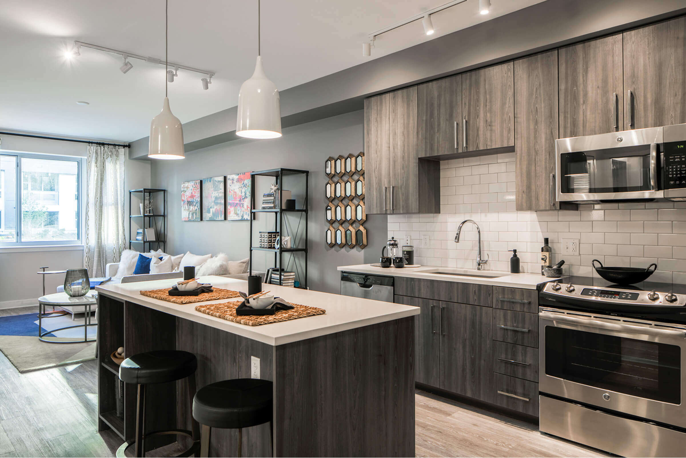 A well lit designer kitchen with quartz tops and hardwood floor